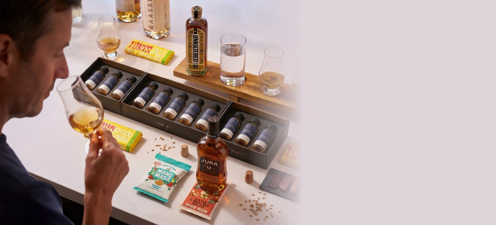 Whisky tasting sets, snacks and glassware laid out on a table